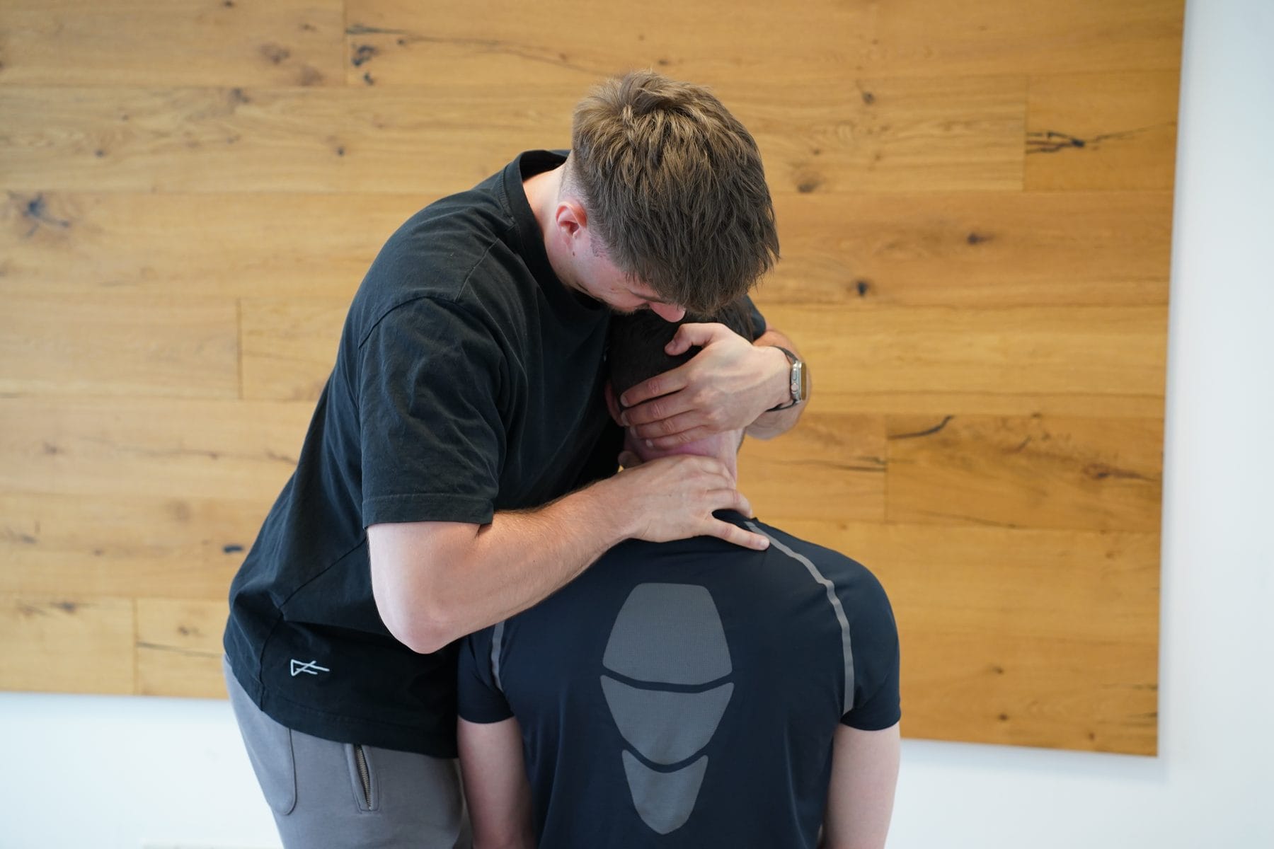 Manuelle Therapie am Nacken, der Therapeut hält den Kopf mit beiden Händen